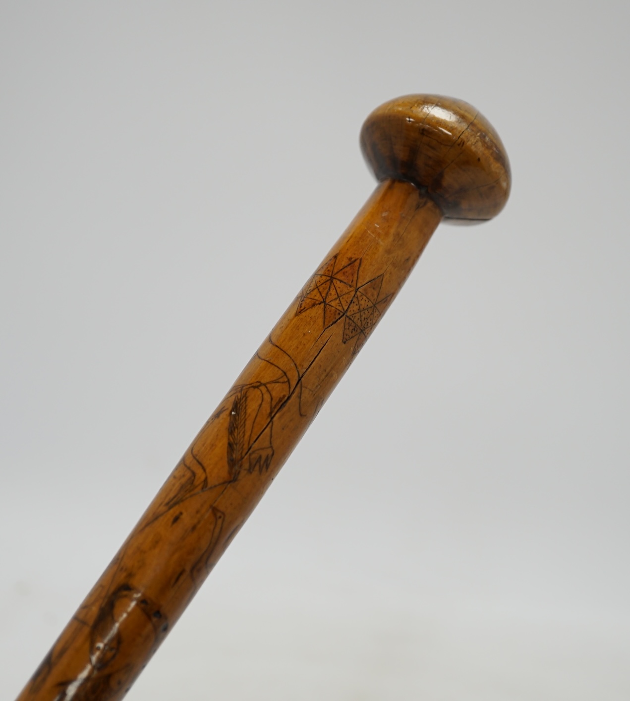 An aboriginal walking stick, inscribed Alice Adelaide, Queenstown, with primitively incised animal and bird imagery, 96cm long. Condition - crack to knob/handle and bottom section worn, central section with incised image